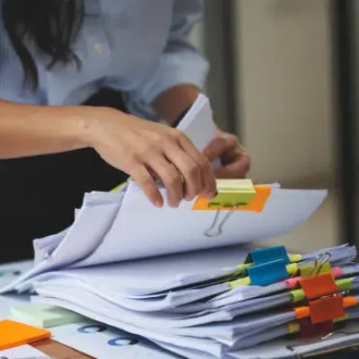 Businesswoman hands working in Stacks of paper files for searching and checking unfinished document achieves on folders papers